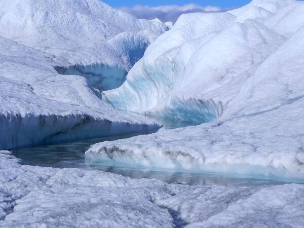 آب مذاب از یخ که سرازیر شده و دریای باریکی را در دامنه کوه شکل داده است. - اسپوتنیک افغانستان  