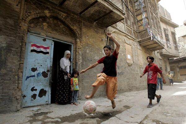 کودکان در خیابانی در محله فاضل بغداد، عراق، 2008 فوتبال بازی می کنند. - اسپوتنیک افغانستان  
