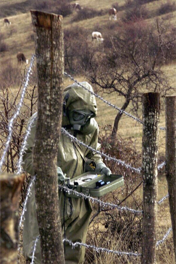 متخصصین در نزدیکی یک سرباز قوای یوگسلاوی که میزان رادیواکتیو را در منطقه مورد هدف در طی بمباران ناتو به یوگسلاوی اندازه گیری می کند، در روستای رلیان، در نزدیکی شهر پرشوو در جنوب صربستان، سه شنبه 9 جنوری 2001. کارشناسان در بلگراد گفته اند که کاهش یافته است. اورانیوم موجود در بمب‌های مورد استفاده در عملیات هوایی ناتو برای میلیاردها سال در خاک باقی می‌ماند و در زمین، آب فیلتر می‌شود و به زنجیره غذایی منتقل می‌شود. - اسپوتنیک افغانستان  