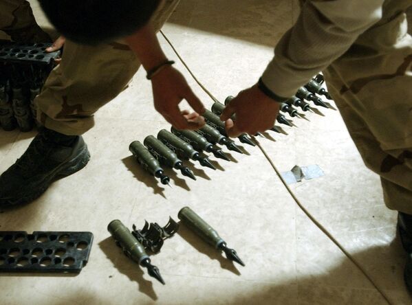 قوای ایالات متحده Spcl. سرجیو کاردناس از گروهان چارلی، از کندک 1-22، فرقه 4 پیاده نظام، بیش از گلوله های 25 میلی متری اورانیوم ضعیف شده، 11 فبروری 2004، در پایگاه خود در تکریت، 180 کیلومتری (110 مایلی) شمال بغداد ایستاده است. سربازان در حال تهیه موجودی مهمات بودند که می خواستند بسته بندی کنند تا به خانه در ایالات متحده بروند. - اسپوتنیک افغانستان  