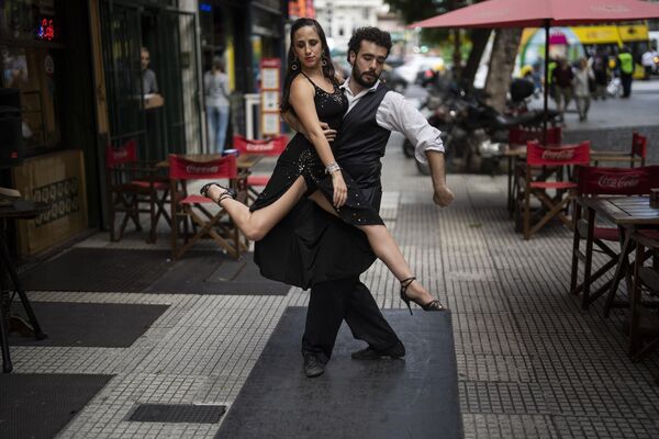 هنرمندان امیلیا گارسیا مارکز و فدریکو کاچرو در خارج از رستورانی در مرکز شهر بوئنوس آیرس، آرژانتین برای گردشگران تانگو می رقصند.  - اسپوتنیک افغانستان  