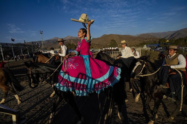 یک زن مکزیکی در اولین جلسه تیم سوارکاری کولینا در کولینا، سانتیاگو کلاه خود را بالا می‌برد.کشورهایی که در آن حضور دارند عبارتند از شیلی، آرژانتین، اسپانیا، مکزیک، پرو و پاناما.18 مارچ، 2023. - اسپوتنیک افغانستان  