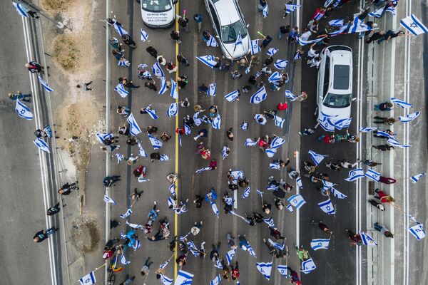اعتراض اسرائیلی‌ها به طرح‌های دولت بنیامین نتانیاهو، نخست‌وزیر، برای بازنگری در سیستم قضایی در مبادله بیت بیت یانایی، اسرائیل در حالی که راه آزاد را مسدود می‌کنند.پنجشنبه 23 مارچ 2023. - اسپوتنیک افغانستان  