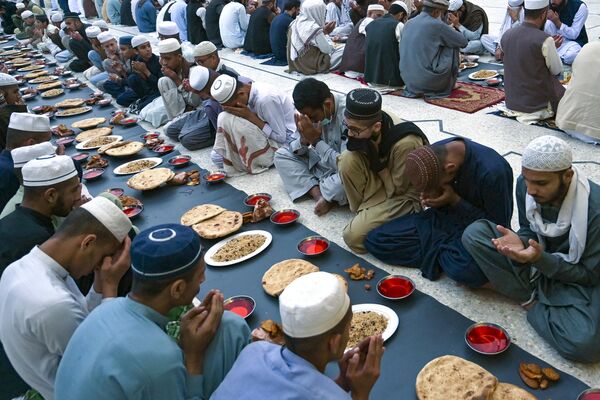 مسلمانان قبل افطار روزه در روز اول ماه رمضان در پشاور، دعا می کنند. - اسپوتنیک افغانستان  
