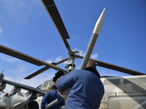پرسنل فنی موشک‌های هواپیمای هدایت‌نشده (NARs) را پیش از سورتی پرواز در منطقه عملیات نظامی ویژه در یگانی که بر روی هلیکوپتر کا-52 نصب شده است، بار می‌کنند. - اسپوتنیک افغانستان  