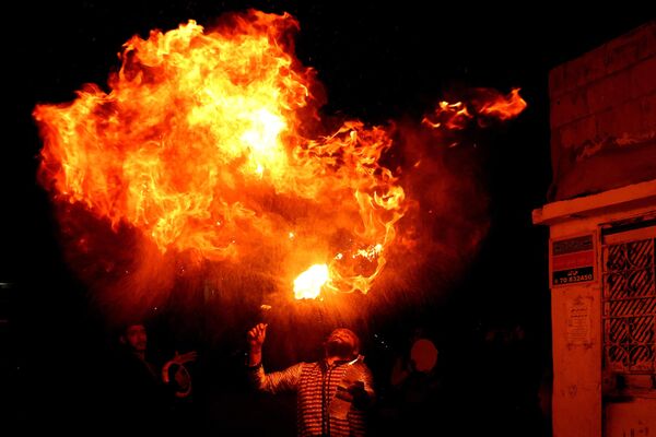 یک اجراکننده در ماه مبارک رمضان در شهر صیدا در جنوب لبنان نمایش آتش بازی را انجام میدهددر 31 مارچ 2023(عکس از جوزف عید / خبرگزاری فرانسه) - اسپوتنیک افغانستان  