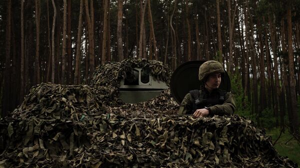 Солдат Национальной гвардии Украины сидит внутри танка на позиции под Харьковом - اسپوتنیک افغانستان  