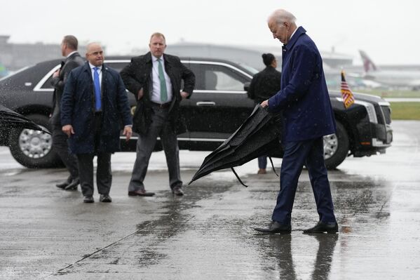 رئیس جمهور جو بایدن چتر خود را هنگام ورود به فرودگاه بین المللی دوبلین در  ایرلند،  باز می کند. چهارشنبه 12 آوریل . - اسپوتنیک افغانستان  
