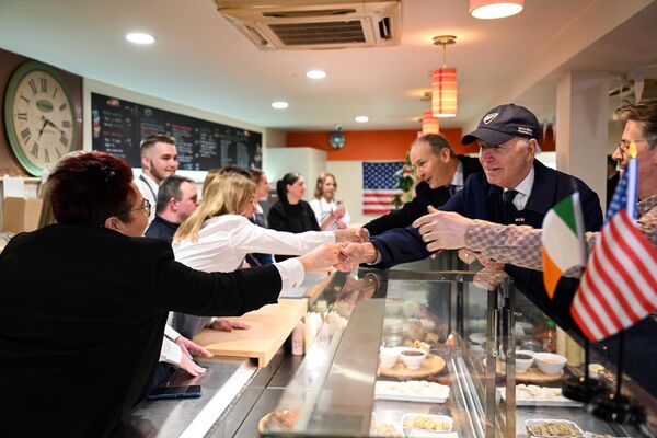 جو بایدن، رئیس جمهور ایالات متحده  و وزیر امور خارجه ایرلند، مایکل مارتین  در طی یک تور از داو تاون دوندالک، در  به عنوان بخشی از چهار روز با اعضای عمومی در خانه غذا مک آترزدر تاریخ 12 اپریل 2023 ملاقات کردند. - اسپوتنیک افغانستان  