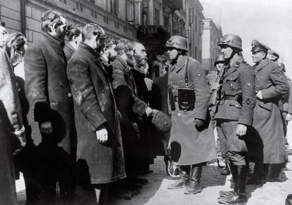 تصویری که در سال 1943 از سربازان آلمانی نازی در حال بازجویی از یهودیان پس از قیام گتوی ورشو گرفته شده است. - اسپوتنیک افغانستان  