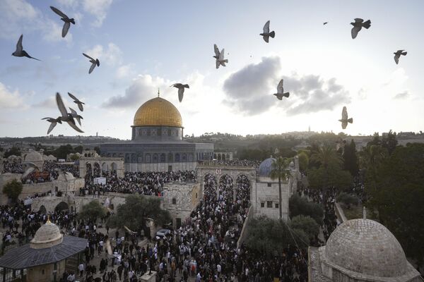 فلسطینی ها در جشن عید سعید فطر در کنار زیارتگاه قبه الصخره در محوطه مسجد الاقصی در شهر قدیمی بیت المقدس، جمعه، 21 اپریل 2023 شرکت می کنند. این تعطیلات نشان دهنده پایان ماه مبارک رمضان است، زمانی که مسلمانان مؤمن از طلوع تا غروب آفتاب روزه می گیرند.  - اسپوتنیک افغانستان  