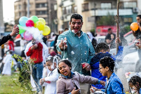 جشنگران مسلمان بعد از نماز روز اول عید سعید فطر به مناسبت پایان ماه رمضان در خارج از مسجد الصدیق مصر در قاهره به یکدیگر کف می پاشند. - اسپوتنیک افغانستان  