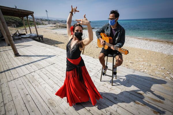 رقصنده آرژانتینی ماریا بلن سیاشی، که به دلیل همه گیری ویروس کرونا کووید-19 در لبنان گیر افتاده است ، در یک پیاده رو ساحلی در شهر ساحلی شمالی باتروون، با موسیقی پخش شده توسط خواننده اروگوئه والتر خاوییر موللو رقص می کند. در 15 آپریل 2020   (عکس ابراهیم چالوب / AFP) - اسپوتنیک افغانستان  