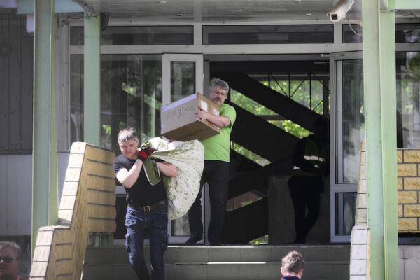 مردان یک بوجی و یک جعبه با یک متن سیریلیک  را از مکتب روسیه در ورشو انتقال می دهند. - اسپوتنیک افغانستان  