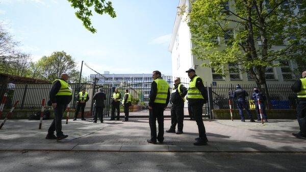 Представители мэрии в сопровождении полиции стоят возле ворот школы при российском посольстве в Варшаве - اسپوتنیک افغانستان  