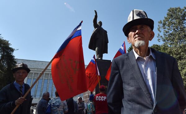 حامیان حزب کمونیست قرقیزستان پرچم‌های سرخ را در مقابل بنای یادبود ولادیمیر لنین بنیانگذار اتحاد جماهیر شوروی در دست دارند. بیشکک ،1 می 2023. - اسپوتنیک افغانستان  