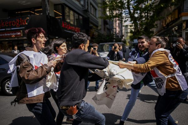یک پولیس با لباس شخصی، پشت دوربین، با اعضای اتحادیه در حالی که در جشن روز کارگر در استانبول راهپیمایی می کنند، درگیر می شود. - اسپوتنیک افغانستان  