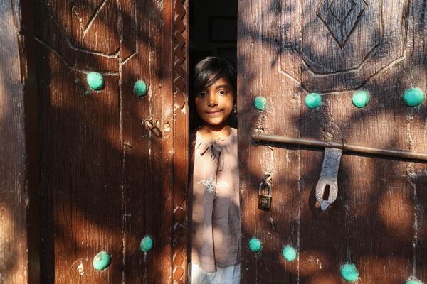 تصویری که در 29 آپریل 2023 گرفته شده است، دختری را نشان می دهد که از داخل دریچه ای در جزیره قشم در خلیج فارس نگاه می کند. - اسپوتنیک افغانستان  