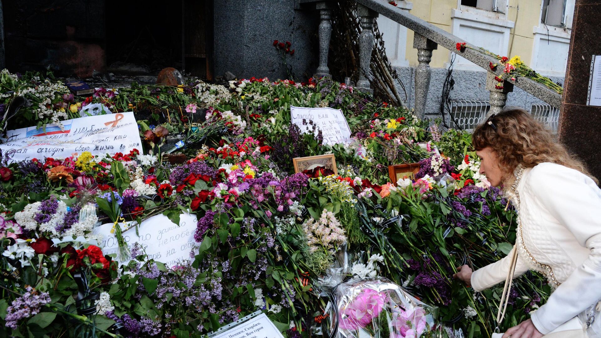 Жительница Мариуполя кладет цветы в память о погибших в здании городского управления милиции, 2014 год - اسپوتنیک افغانستان  , 1920, 06.05.2023
