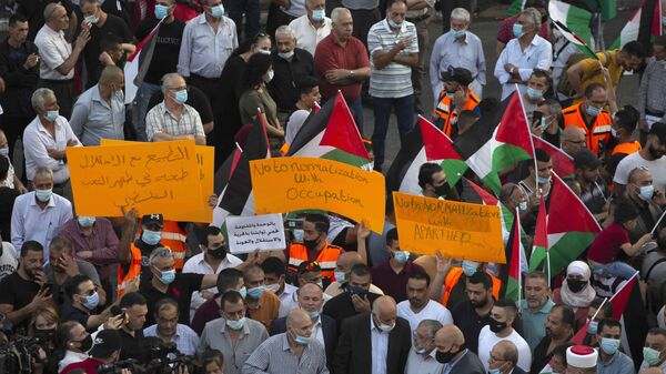 Палестинцы размахивают национальными флагами во время акции протеста против нормализации отношений между Объединенными Арабскими Эмиратами и Бахрейном с Израилем - اسپوتنیک افغانستان  