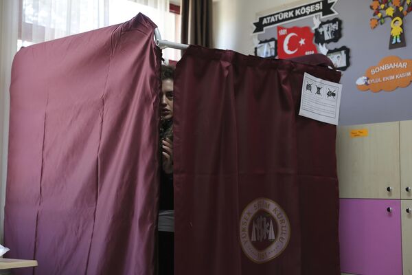 یک زن در یک مرکز رای گیری در انقره، ترکیه، یکشنبه، 14 می 2023، رای می دهد. رای دهندگان در ترکیه روز یکشنبه برای انتخابات پارلمانی و ریاست جمهوری که انتظار می رود رقابت شدیدی برگزار شود و می تواند بزرگترین چالش رئیس جمهور ترکیه باشد، به پای صندوق های رای می روند. رجب طیب اردوغان در دو دهه قدرت خود با آن مواجه است. (عکس خبرگزاری فرانسه) - اسپوتنیک افغانستان  