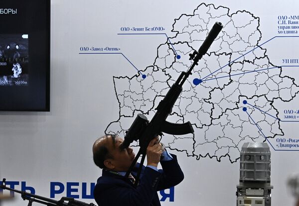یک بازدید کننده با سلاح در دست در یازدهمین نمایشگاه بین المللی تسلیحات و تجهیزات نظامی MILEX-2023 در مینسک، پایتخت بلاروس. - اسپوتنیک افغانستان  