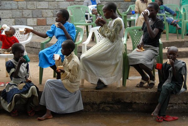 کودکان در روز چهارشنبه، 13 فیبروری 2008، در یک اردوگاه ترانزیت آوارگان در کیسومو، کنیا، برای صبحانه چای و نان می خورند. بر اساس گزارش، 600000 نفر به دلیل خشونت ناشی از اختلاف بر سر اینکه چه کسی در انتخابات ریاست جمهوری کنیا برنده شد، خانه های خود را ترک کردند. گزارش سازمان ملل (عکس از ریکاردو گانگالی) - اسپوتنیک افغانستان  