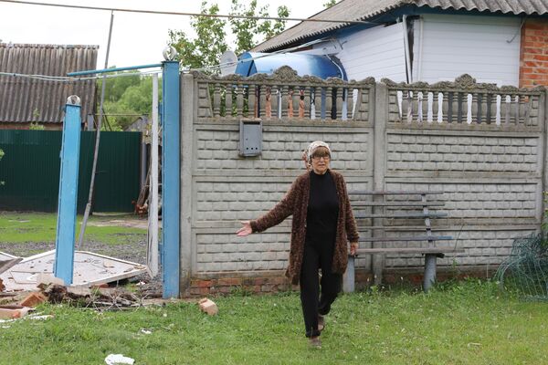یکی از ساکنان محلی در یکی از شهرک‌های منطقه گرایورونسکی در منطقه بلگورود، آسیب‌های وارده به خانه‌اش را پس از حمله توسط جنایتکاران اوکراین را نشان می‌دهد. - اسپوتنیک افغانستان  