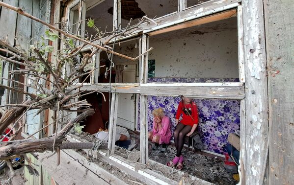 ساکنان خانه ای در گورلووکا، جمهوری خلق دونتسک، که از تیر باران نیروهای مسلح اوکراین آسیب دیده است. در نتیجه گلوله باران یک مرد کشته شد. - اسپوتنیک افغانستان  