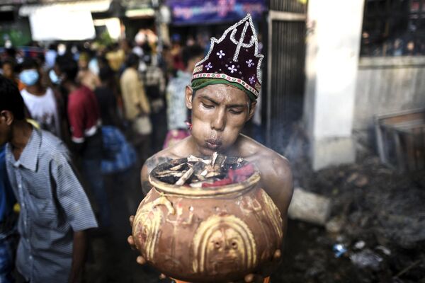 یک هندو از راه می رسد تا روی زغال سوزان در جشنواره راهپیمایی در یانگون در 28 می 2023 راه برود. - اسپوتنیک افغانستان  