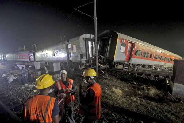امدادگران در محل حادثه قطارهای مسافری، در منطقه بالاسوره، در ایالت شرقی اوریسا هند، شنبه، 3 جون 2023، کار می کنند. - اسپوتنیک افغانستان  