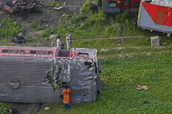 توجه ویراستاران: محتوای گرافیکی / پولیس واگن‌های شکسته یک برخورد سه قطار در نزدیکی بالاسوره، در ایالت شرقی اودیشا هند، در 4 جون 2023 را بازرسی می‌کند. مقامات در 4 جون در تلاش هستند تا علت برخورد سه قطار را در هند درک کنند، که دست کم 288 نفر در آن کشته شد و مدعی شد که &quot;هیچ کس مسئول&quot; در امان نخواهد ماند. (عکس از دیبیانگشو خبرگزاری فرانسه)  - اسپوتنیک افغانستان  