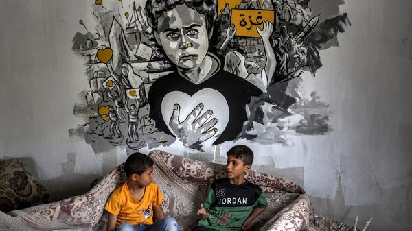 Палестинские дети сидят под фреской во время выставки под названием Oккупация убивает детство в Газе, Палестина - اسپوتنیک افغانستان  