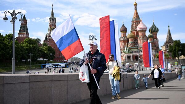 Мужчина с российским национальным флагом у Кремля в центре Москвы - اسپوتنیک افغانستان  