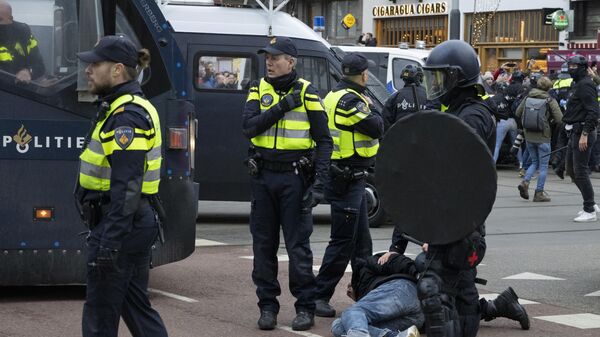 Полиция арестовывает демонстранта во время протестов в Амстердаме - اسپوتنیک افغانستان  
