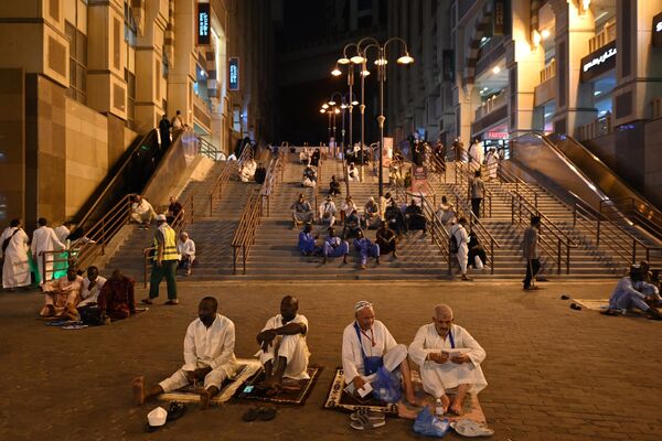 زائران حج در حالی که مسلمانان از سراسر جهان برای شرکت در مراسم سالانه حج در شهر مقدس مکه عربستان می‌آیند، در خیابانی استراحت می‌کنند.23 جون 2023 - اسپوتنیک افغانستان  