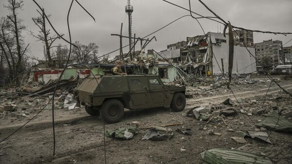 Военная машина проезжает по разрушенному после обстрела району в городе Авдеевка Донецкой области, 18 марта 2023 года - اسپوتنیک افغانستان  