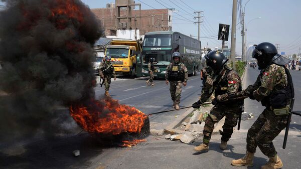 Полиция убирает горящие шины с центрального шоссе, где припаркованы грузовики и автобусы, чтобы перекрыть дорогу в Уайкане на окраине Лимы, Перу - اسپوتنیک افغانستان  