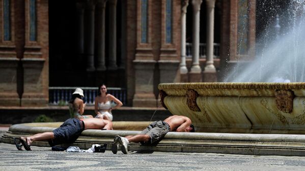 اسپانیا سومین کشور که موج شدید گرما را تجربه میکند است و در این تصویر که در تاریخ 7 آگوست گرفته شده است دیده می شود دو جوان برای خنک شدن سرشان را در آب یک فواره در میدان Plaza de Espana واقع در شهر در سویل فرو می‌کنند. - اسپوتنیک افغانستان  