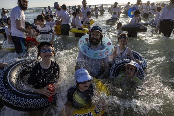 یهودیان افراطی ارتدوکس در ساحل شهر اسدود در جنوب اسرائیل شنا می کنند، در طول دوره تعطیلات خود در یشیواهای ارتدوکس یهودی (موسسات آموزشی سنتی یهودی)9 آگوست 2023 - اسپوتنیک افغانستان  