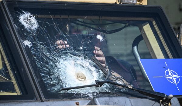 مردی از طریق شیشه جلوی ترک خورده هاسکی بریتانیایی APC (نفر بر زرهی) که در میدان نمایشگاه در پارک پاتریوت کوبینکا به نمایش گذاشته شده است عکس می گیرد. - اسپوتنیک افغانستان  