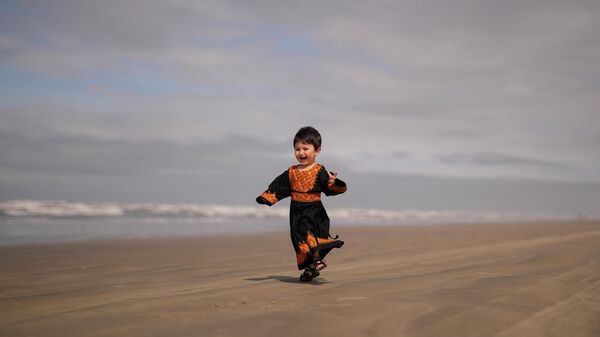 Двухлетняя афганская беженка Фарния Хассани играет на пляже в Прайя-Гранди, штат Сан-Паулу, Бразилия - اسپوتنیک افغانستان  