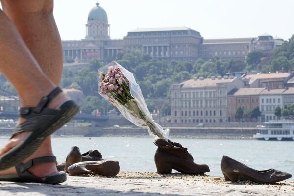 در 26 آگست 2023، مردم در یادبود کفش‌های یهودی در امتداد ساحل دانوب در مقابل قلعه بوداپست، به یاد یهودیان بوداپست که در سال 1944 توسط ارتش راست افراطی هنگری در بوداپست تیراندازی کردند، گل‌ها را به یادگار گذاشتند. - اسپوتنیک افغانستان  