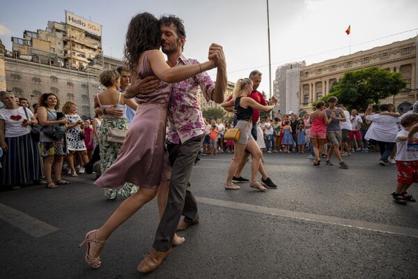 مردم در جریان رویداد شب رقص، شنبه، 26 اگست 2023، در Calea Victoriei، یک خیابان اصلی در بخارست، رومانی، می رقصند.بیش از 200 رقصنده از 45 استودیو به همراه رهگذران با پوشش طیف گسترده ای از سبک های رقص، رقصیدند. - اسپوتنیک افغانستان  