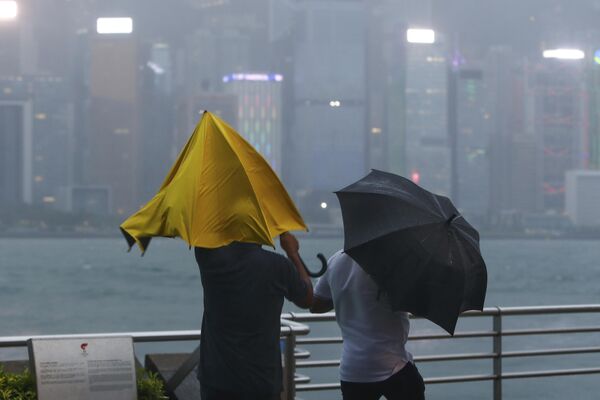 مردم با چتر در برابر باد و باران شدیدی که طوفان فوق العاده سائولا در هنگ کنگ در روز جمعه، 1 سپتامبر 2023 به وقوع پیوست، مبارزه می کنند.بیشتر هنگ کنگ و سایر بخش‌های جنوب چین روز جمعه تقریباً تعطیل شدند و کلاس‌ها و پروازها با نزدیک شدن طوفان قدرتمند سائولا لغو شدند. - اسپوتنیک افغانستان  