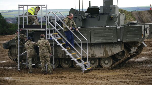 Britain's Defence Secretary Ben Wallace uses steps to climb down from a tank during a visit the Bovington Camp, a British Army military base where Ukrainian soldiers are training on Challenger 2 tanks, in Dorset, England - اسپوتنیک افغانستان  