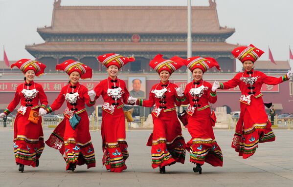 مهمانداران کنگره ملی خلق به نمایندگی از اقلیت ژوانگ از گوانگشی در جنوب غربی چین در میدان تیان‌آن‌من در پکن، در روز جهانی زن، در 8 مارچ 2008، در حالی که جلسه پارلمان سالانه چین در داخل تالار بزرگ مردم برگزار می‌شود، دویدند. - اسپوتنیک افغانستان  