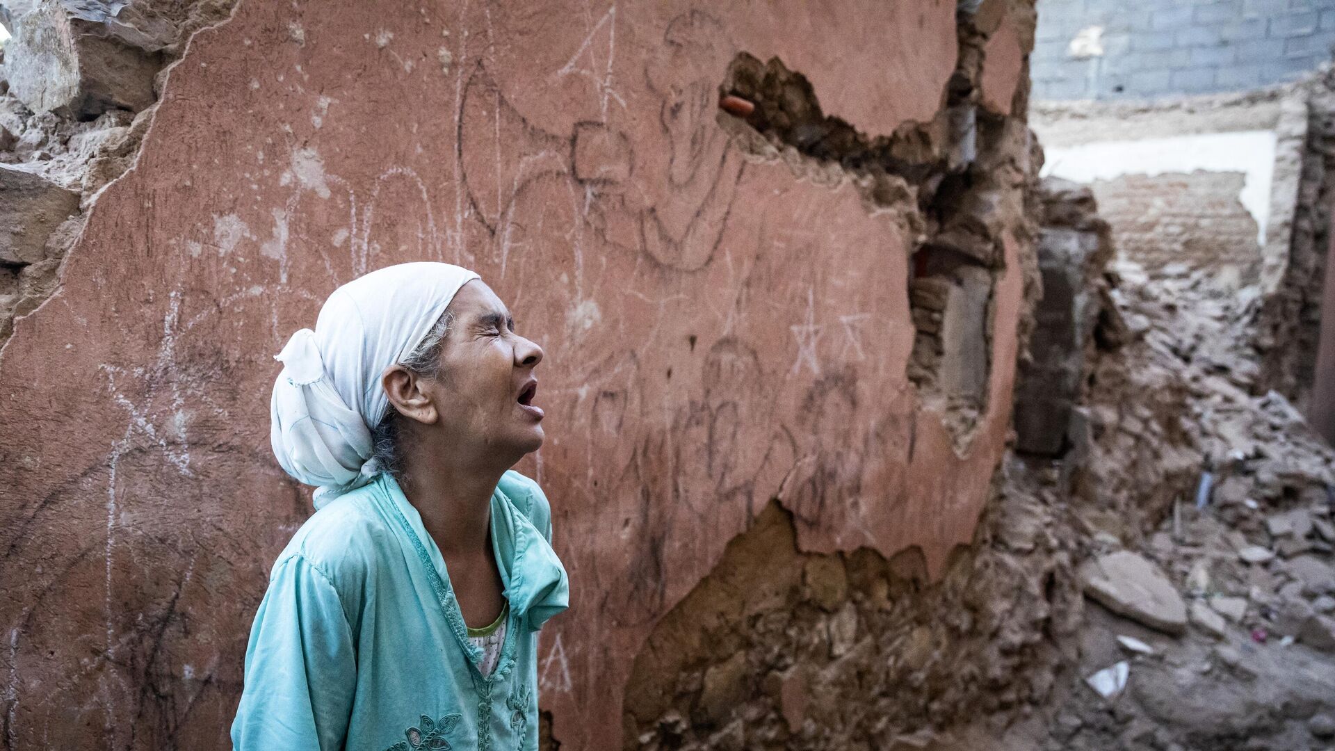 Женщина стоит перед своим поврежденным домом от землетрясения в старом городе Марракеша, Марокко - اسپوتنیک افغانستان  , 1920, 09.09.2023