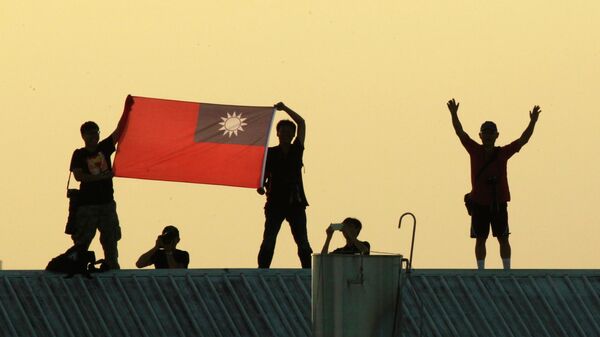 Люди на крыше демонстрируют национальный флаг Тайваня во время учений тайваньских истребителей в Цзяи, Тайвань - اسپوتنیک افغانستان  
