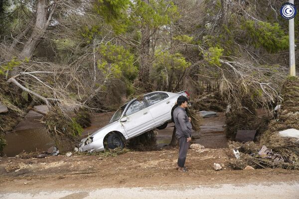 در این عکس ارائه شده توسط دولت لیبیا، خودرویی که در روز دوشنبه، 11 سپتامبر 2023 توسط سیل در درنا لیبیا توسط آب های سیلابی در لیبی حمل شد، در درختان گیر افتاده است. طوفان مدیترانه ای دانیل باعث سیل ویرانگر در لیبیا شد که سدها را شکست و کل محله ها را با خود برد. - اسپوتنیک افغانستان  